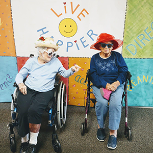 Elderly residents sitting in wheel chair, enjoying each others company
