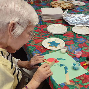 Elderly resident crafting with paint