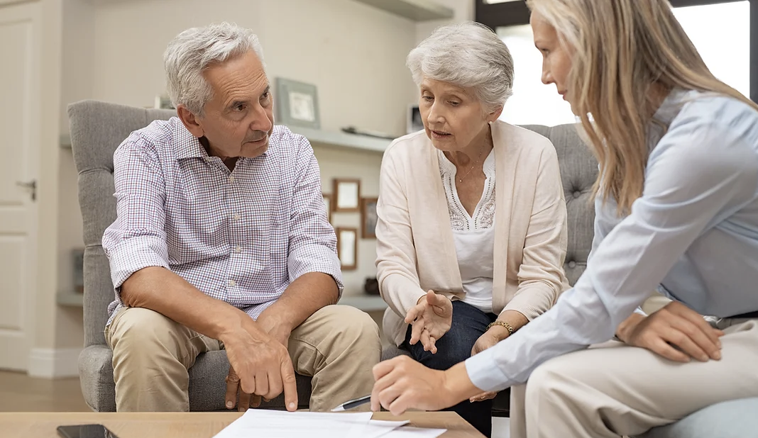elderly couple sitting with a health care professional