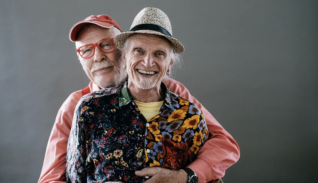 two elderly men hugging and smiling